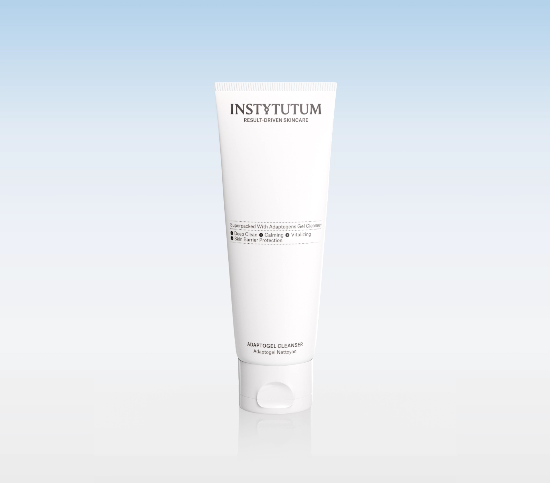 White Instytutum skincare tube (Adaptogel Cleanser) standing upright against a pale blue gradient background, product shot intended for a cleanser.