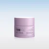 Pink cosmetic jar of 'Firm Magic' firming mask with plant-based collagen support, shown against a soft blue gradient background.