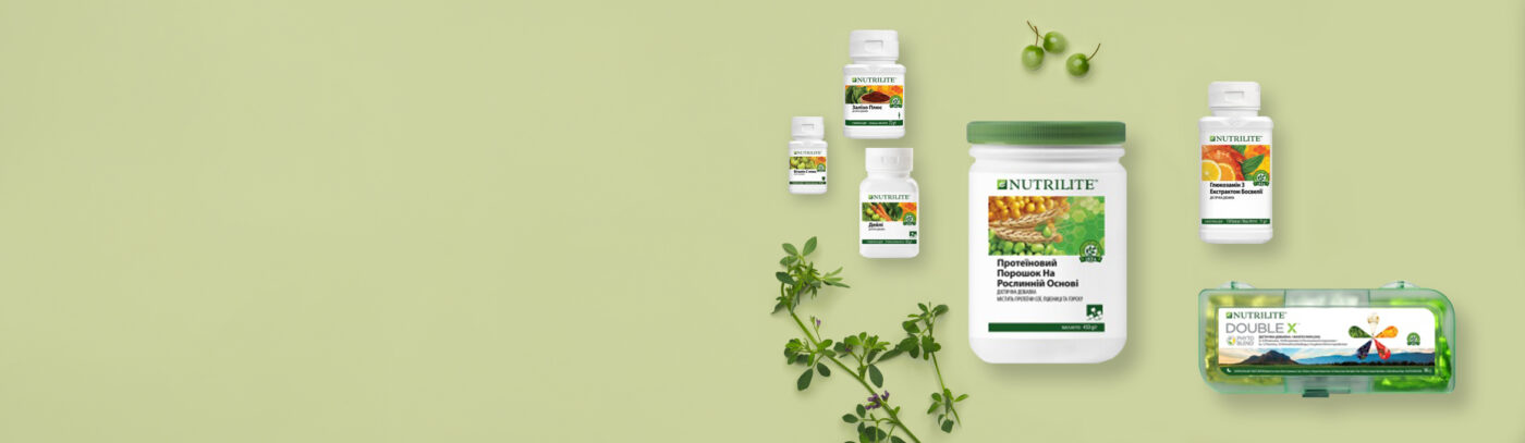 Nutrilite dietary supplements arranged with fresh herbs on a pale green background.