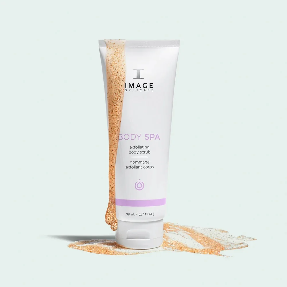 Tube of Image Skincare Body Spa exfoliating body scrub with peach paste spilling beside it against a pale mint background.