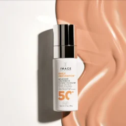 White bottle of IMAGE Skincare Daily Prevention 5C+ mineral moisturizer with SPF 50+ on a white surface, beside peach-toned fabric.