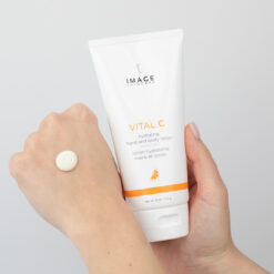 Tube of Image Skincare Vital C hydrating hand and body lotion held in one hand, with a dollop of lotion on the back of the other hand