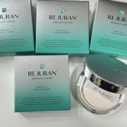 Set of Rejuran Skin Glow Cushion boxes in teal-silver gradient on a white surface, with one open compact showing the cushion and powder inside.