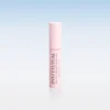 Pink cylindrical cosmetic tube standing upright on a glossy surface with a soft blue-to-white gradient background; branding reads INSTYTUTUM.