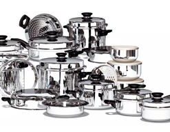 Assorted stainless steel pots and pans with lids arranged together on a white background, varying in size and shape.