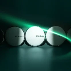 Row of white cosmetic jars labeled Rejuran arranged in a line with a green laser beam across them