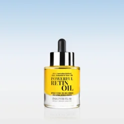 Glass dropper bottle of Instytutum Powerful Retin Oil with yellow liquid and black cap, set against a pale blue gradient background.