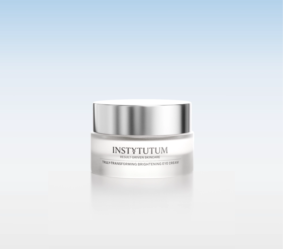 Silver-capped jar of Instytutum Truly-Transforming Brightening Eye Cream on a white reflective surface