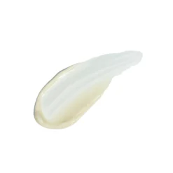 Close-up of a pale cream smear on a white background, like lotion or moisturizer on a surface.