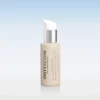 Beige skincare bottle with white pump dispenser and silver collar against a soft blue gradient background.